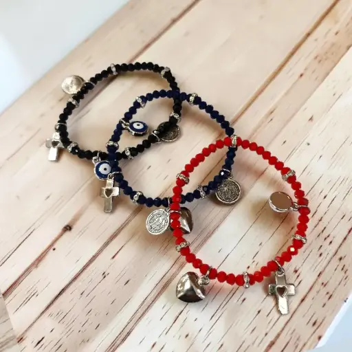 Pulsera Elastica con Dijes Ojo Turco, Cruz, San Benito y Corazon Colores Surtidos 